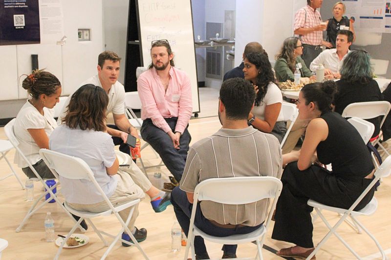 Clinicians, students, and outreach workers seated in a circle for a small-group discussion at the 2025 Street Psychiatry Conference.